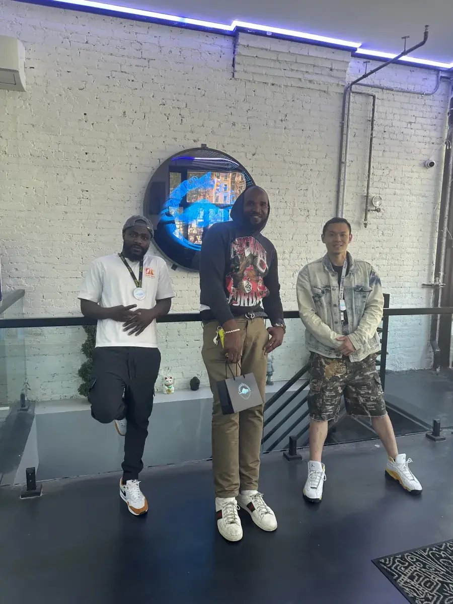 Cannadreams team posing in front of the neon Cannadreams sign in-store