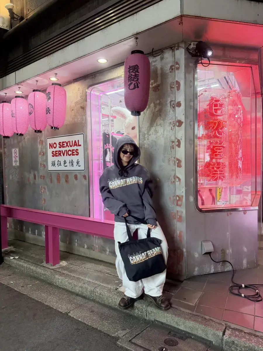 Cannadreams hoodie and tote bag worn in a neon-lit alley in Tokyo, Japan