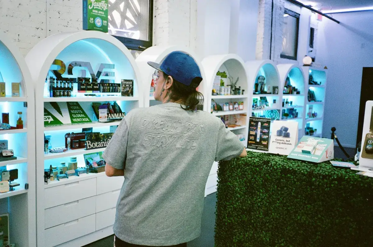 Cannadreams team member wearing the Dream Big, Stay Lit t-shirt inside the dispensary